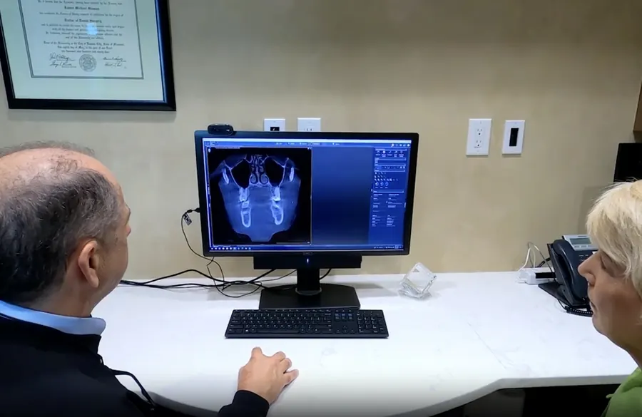 Dr. Slaman reviewing x-ray images on screen with a patient.